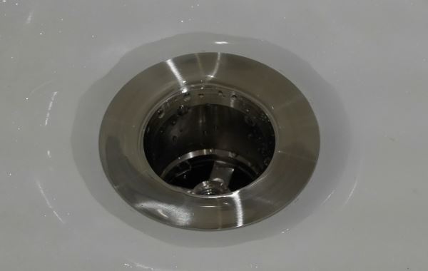 unclog standing water in garbage disposal